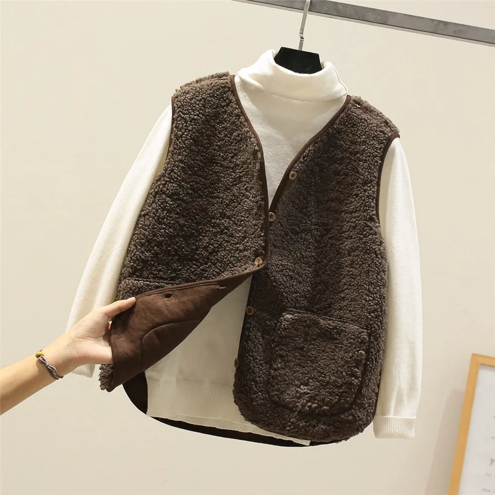 Close-up of fleece gilet fabric texture and button detail on brown sleeveless layering piece