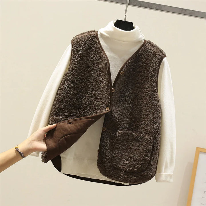 Close-up of fleece gilet fabric texture and button detail on brown sleeveless layering piece