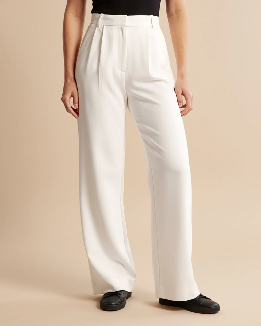 Side angle of high waist pleated trousers showing straight-leg silhouette and clean lines