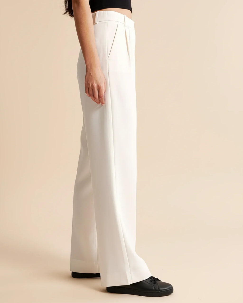 Close-up of pleated trouser fabric showing soft finish and structured tailoring