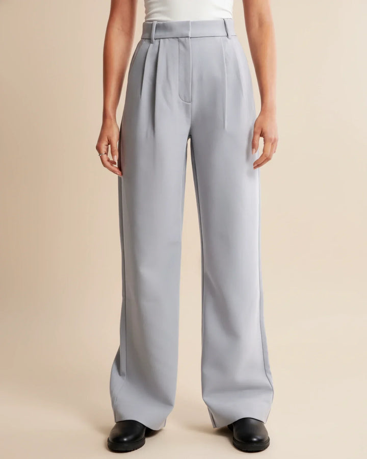 Women's pleated trousers in beige paired with black jumper for versatile styling