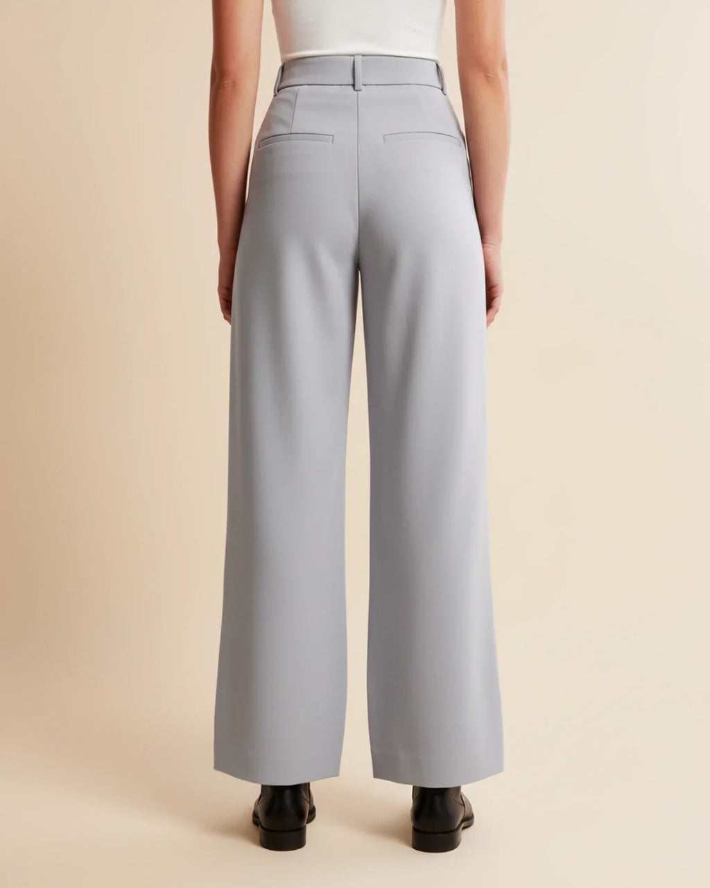 Close-up of pleated trouser design showing front pleats and smooth fabric texture