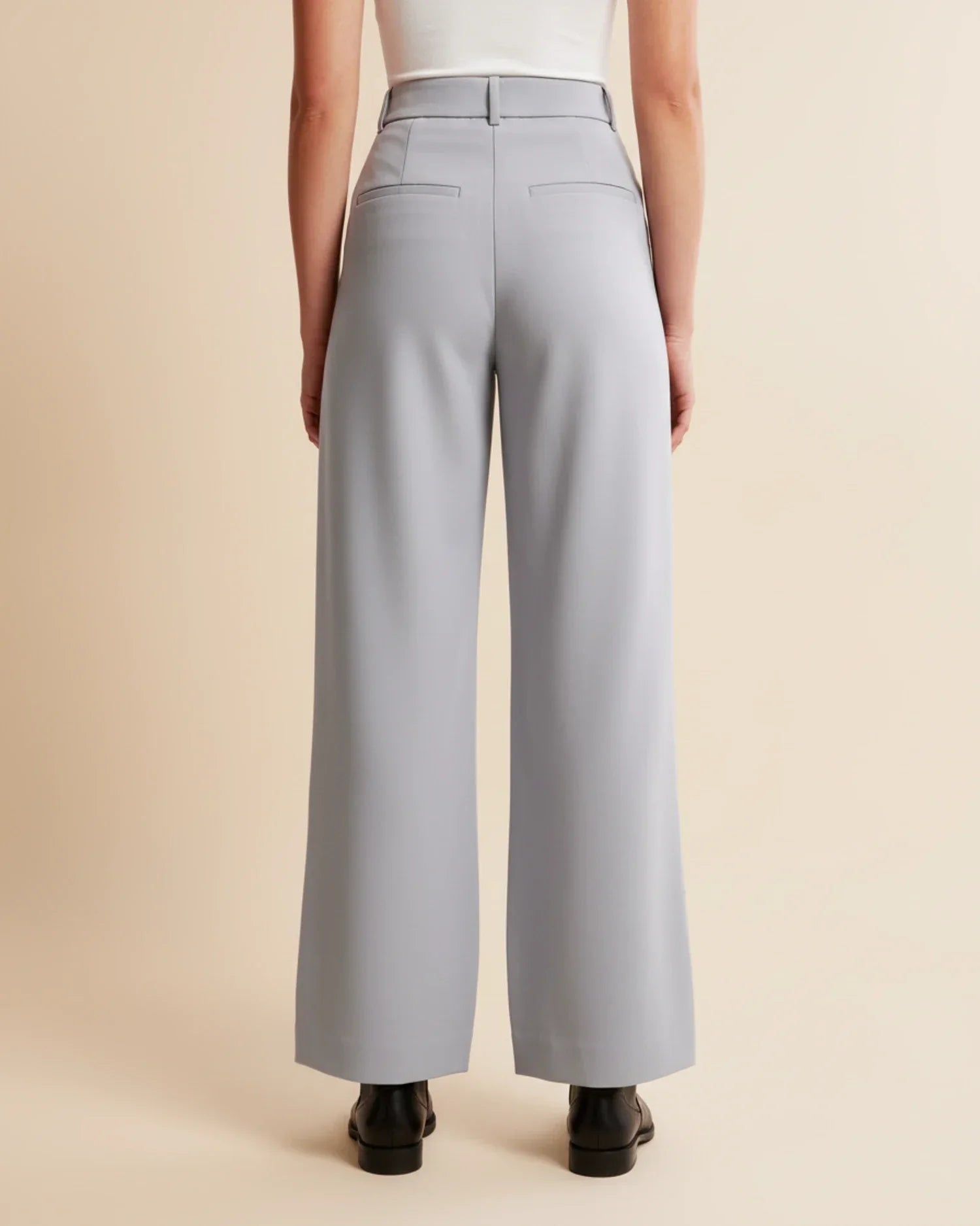 Close-up of pleated trouser design showing front pleats and smooth fabric texture