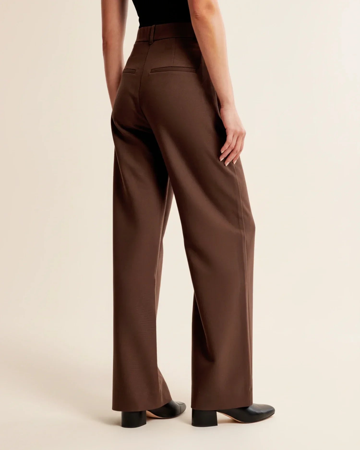 Full-length view of women's pleated trousers in beige with tailored straight-leg cut