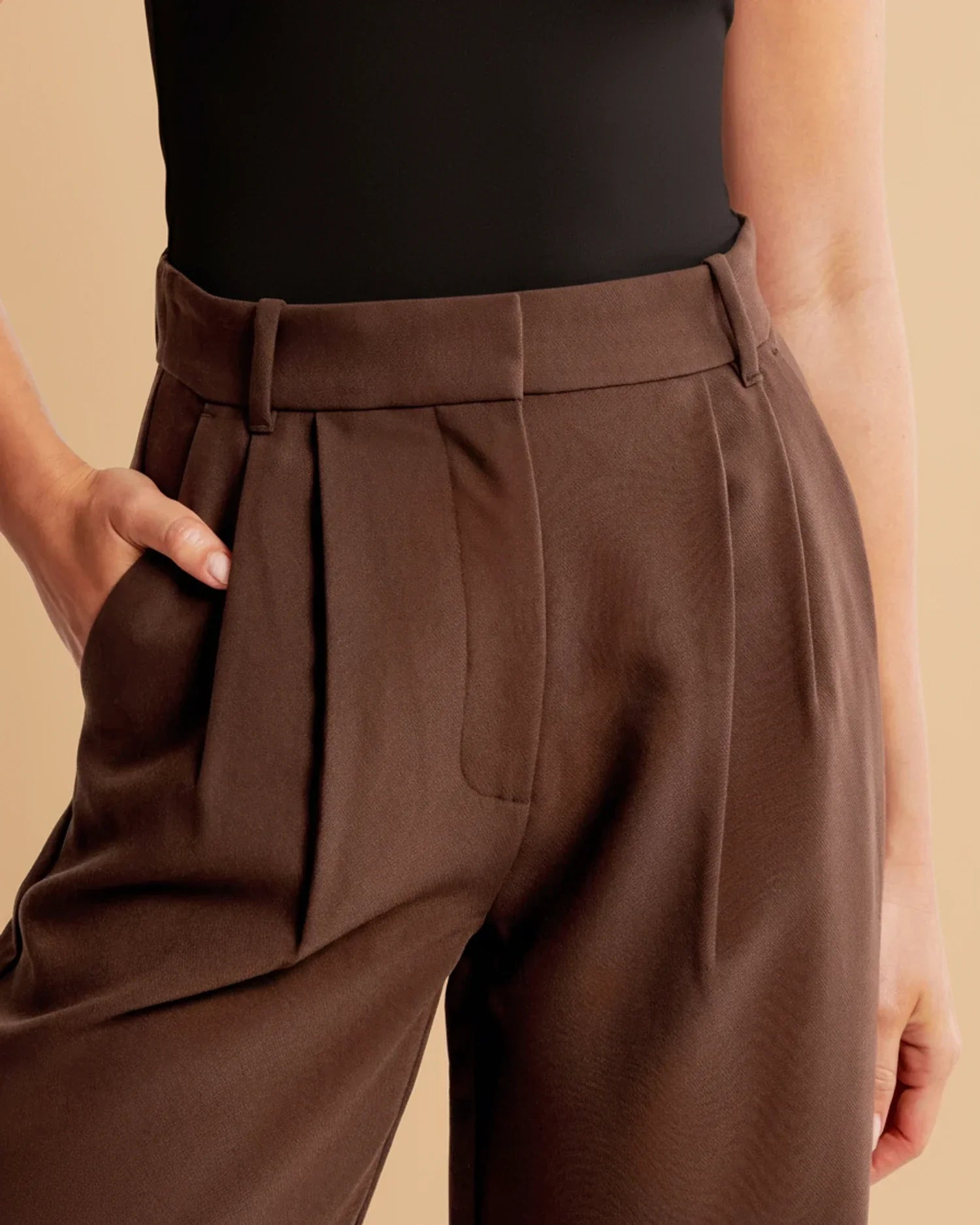 Detail shot of pleated trousers showing versatile styling for casual or formal occasions