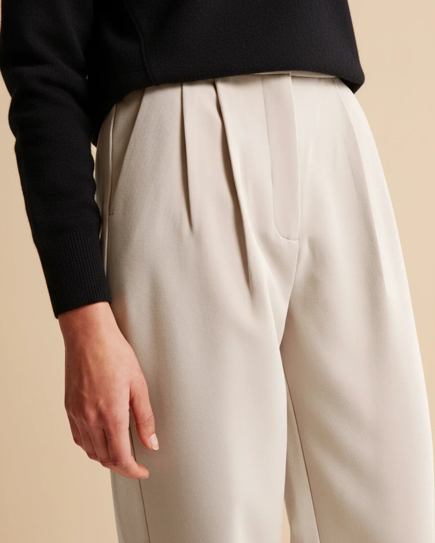 Side view of women's straight-leg pleated trousers with high waist and clean lines