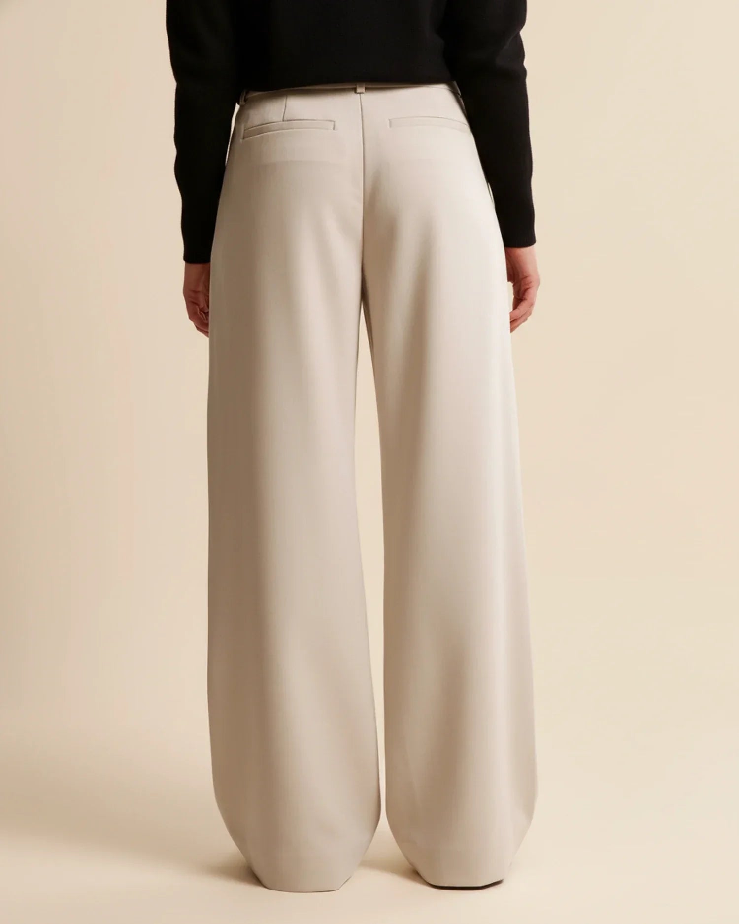 Detail shot of pleated trousers showing smooth fabric finish and tailored construction