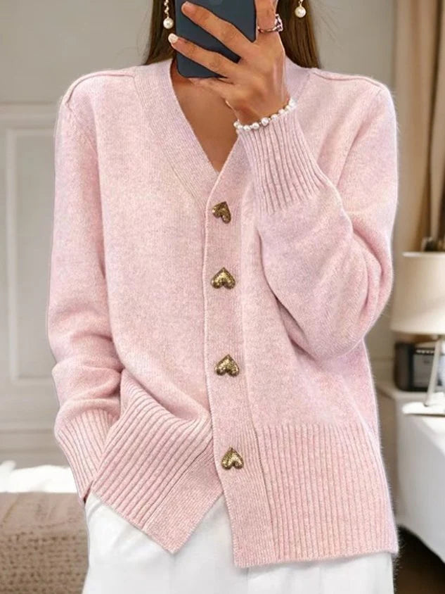Women's black knit cardigan styled with white trousers for a relaxed autumn outfit