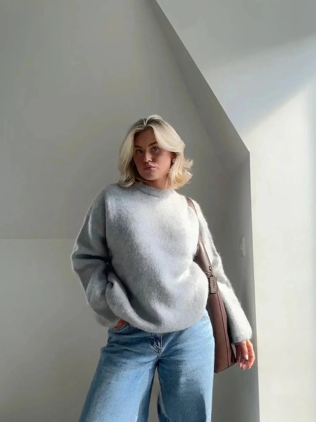 Woman wearing grey oversized crew neck jumper with fluffy textured knit and relaxed fit