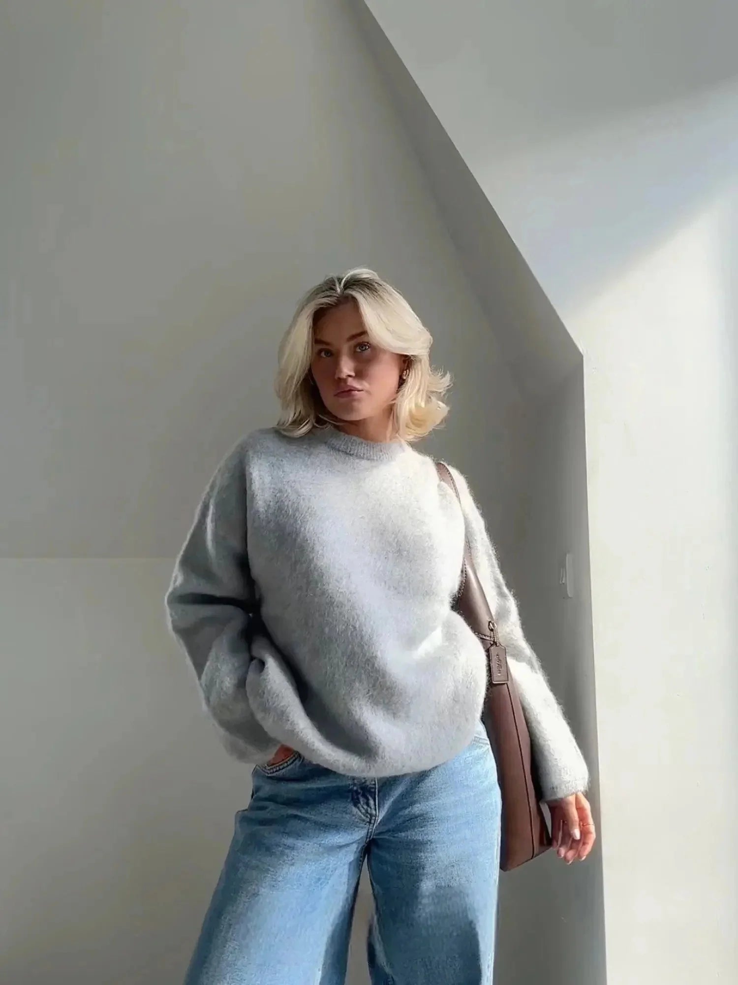 Woman wearing grey oversized crew neck jumper with fluffy textured knit and relaxed fit