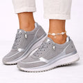 Women's trainers with side zip closure and lace-up front, featuring perforated panels and metallic heel detail in grey