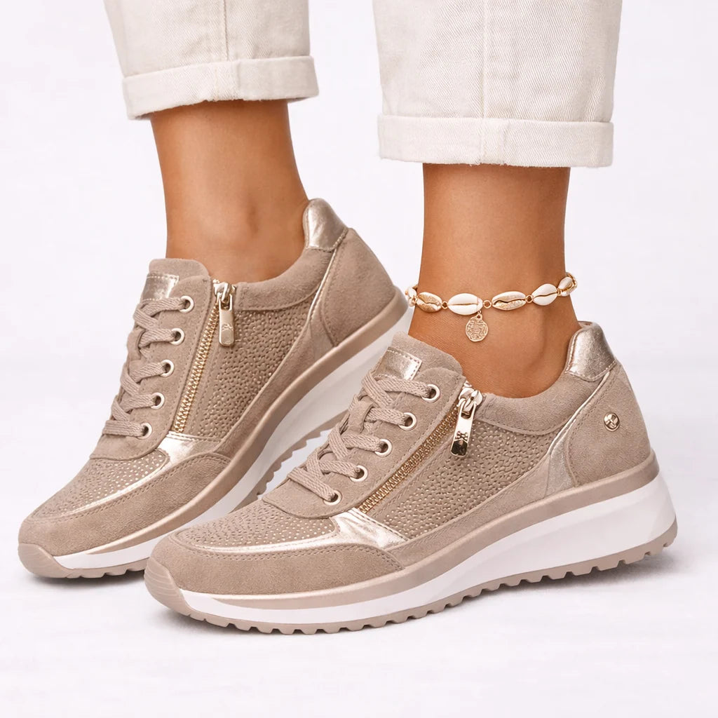 Close-up view of women's trainers showing structured platform sole with textured tread and metallic accents