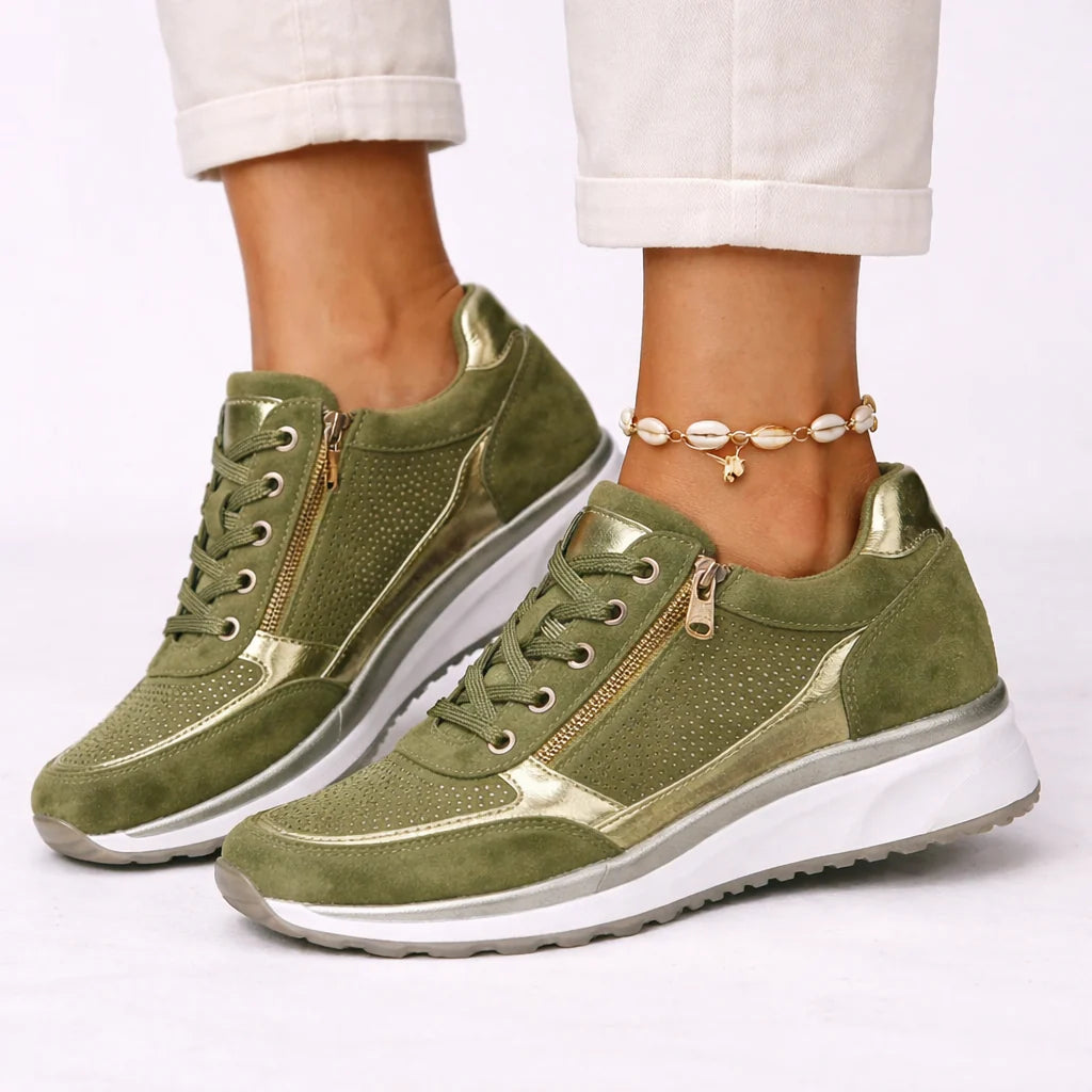 Side angle of women's trainers with side zip and lace-up closure, paired with light trousers and shell anklet