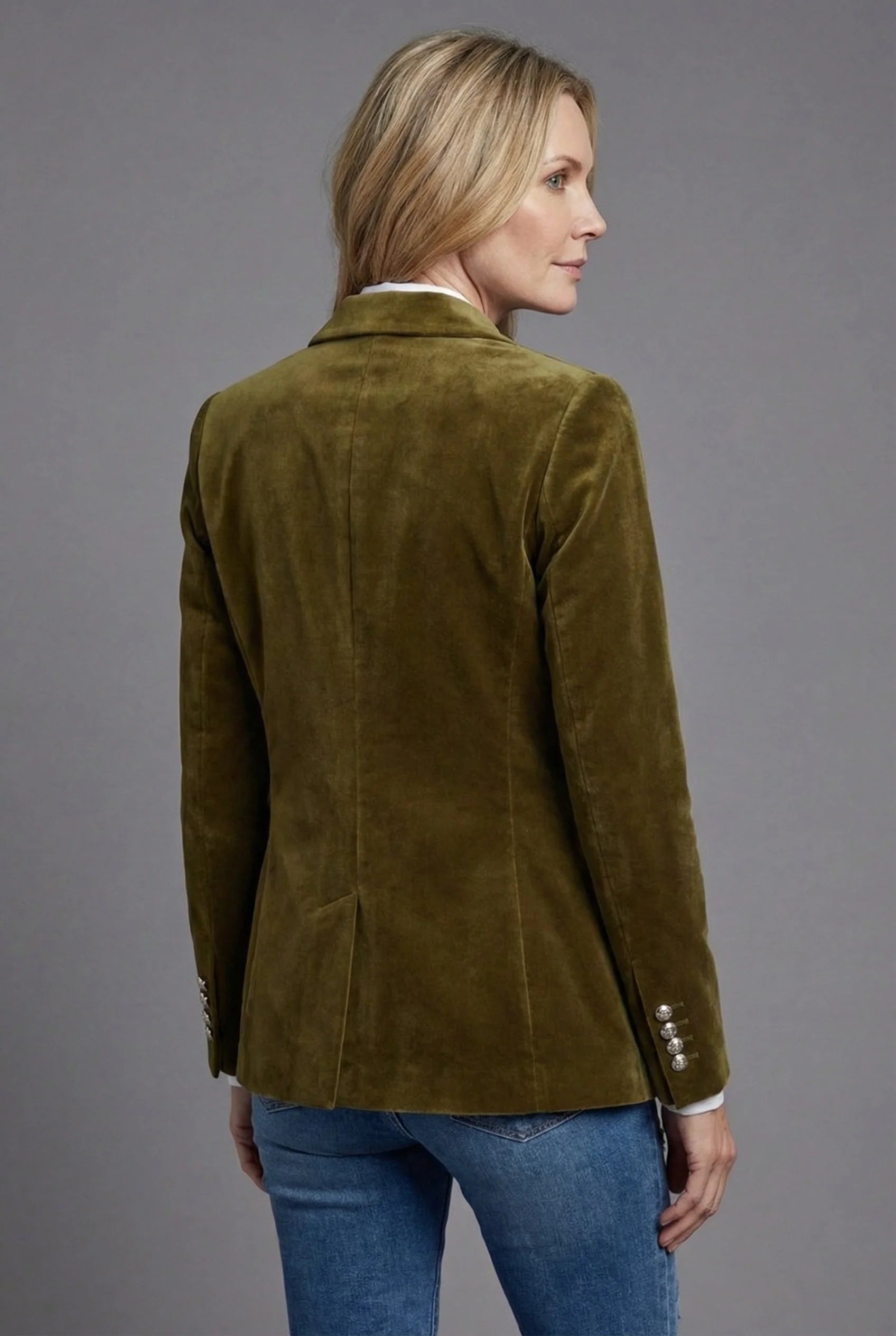 Side view of women's velvet blazer highlighting tailored fit and flap pocket with long sleeves