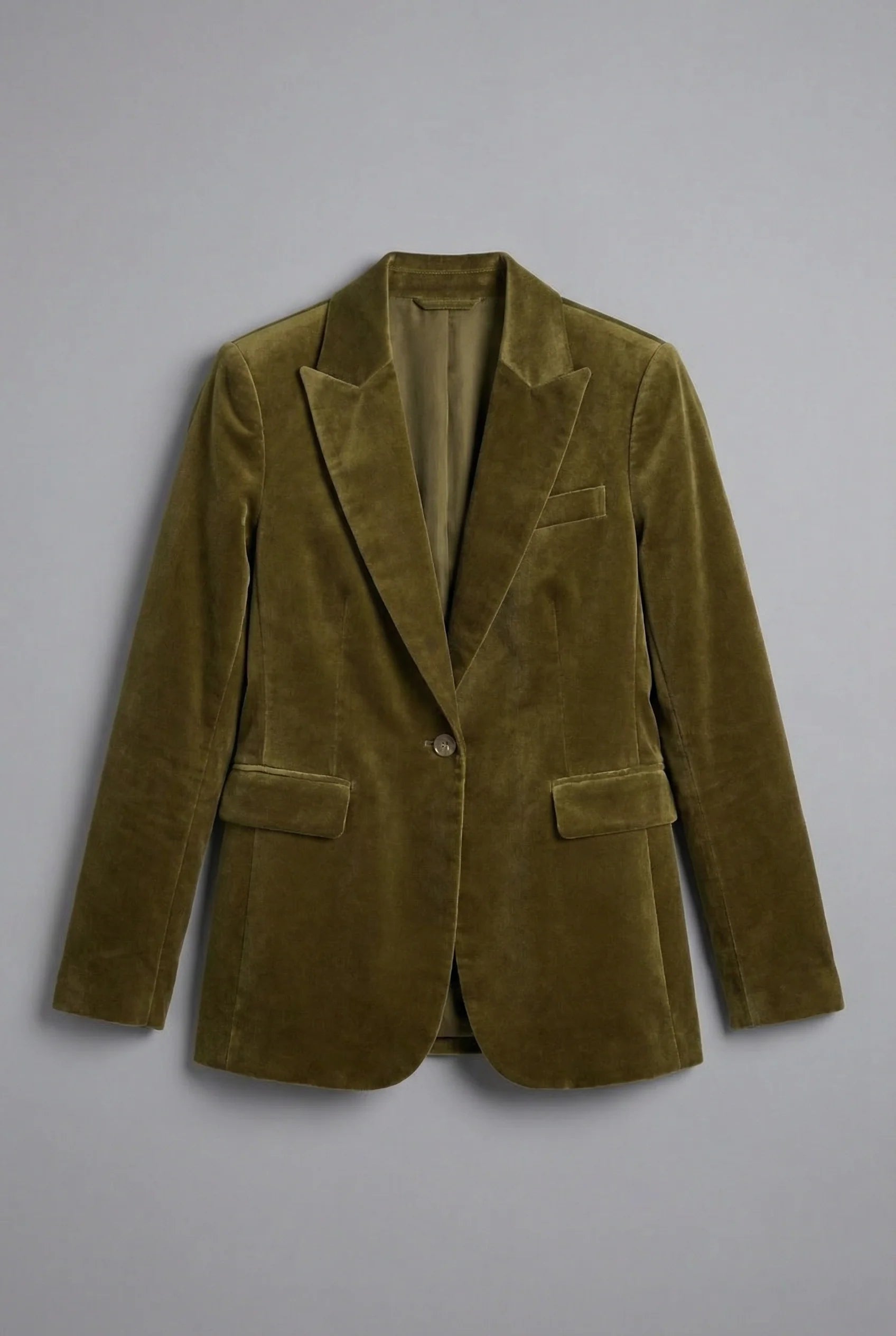 Women's velvet blazer in olive green paired with white shirt and denim jeans showing smart-casual styling