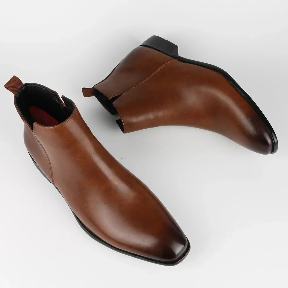 Side view of men's ankle-high Chelsea boots with zip closure and pull tab
