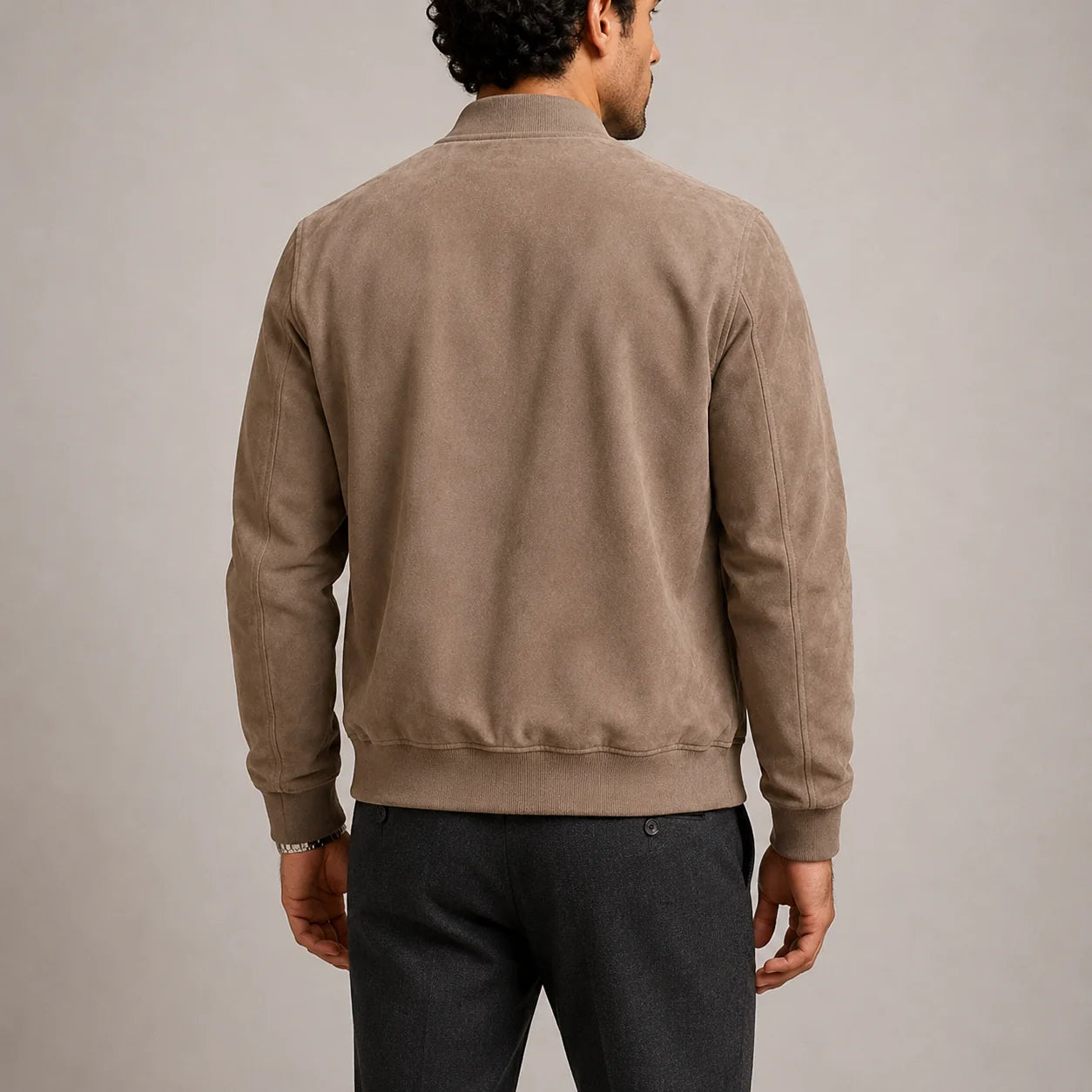 Close-up view of men's suede bomber jacket showing soft suede-effect fabric and ribbed trims