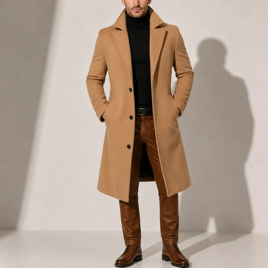 Men's long overcoat in camel with tailored fit and single-breasted button closure, worn over black turtleneck and brown trousers