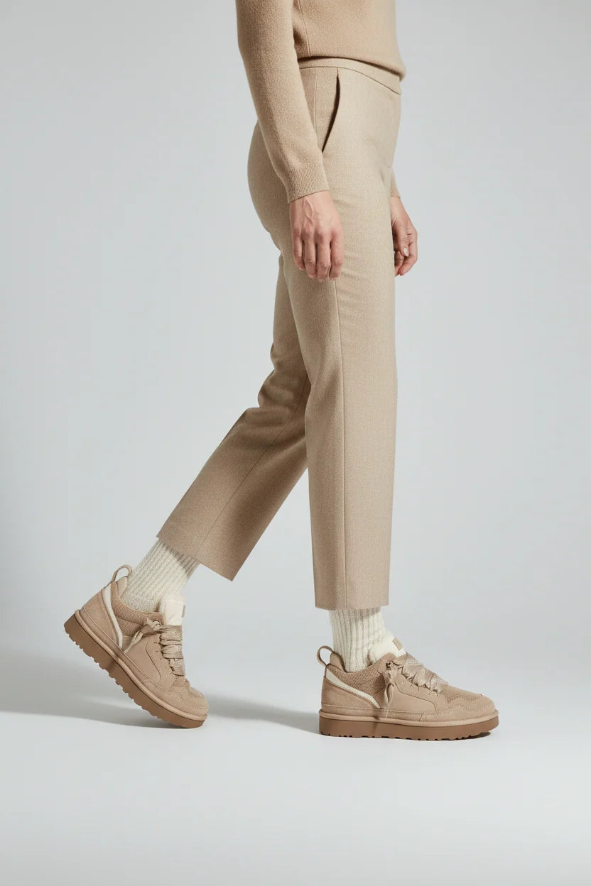 Close-up of beige platform trainers showing lace-up detail and mesh upper construction