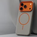 Men's MagSafe iPhone case in grey with raised orange camera surround and magnetic charging ring
