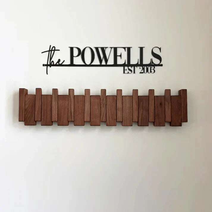 Men's wooden wall coat rack with piano key-inspired hooks mounted on white wall