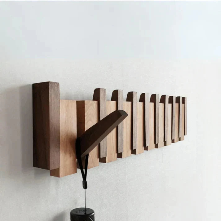 Close-up of beech and walnut wood coat rack showing piano key hook design