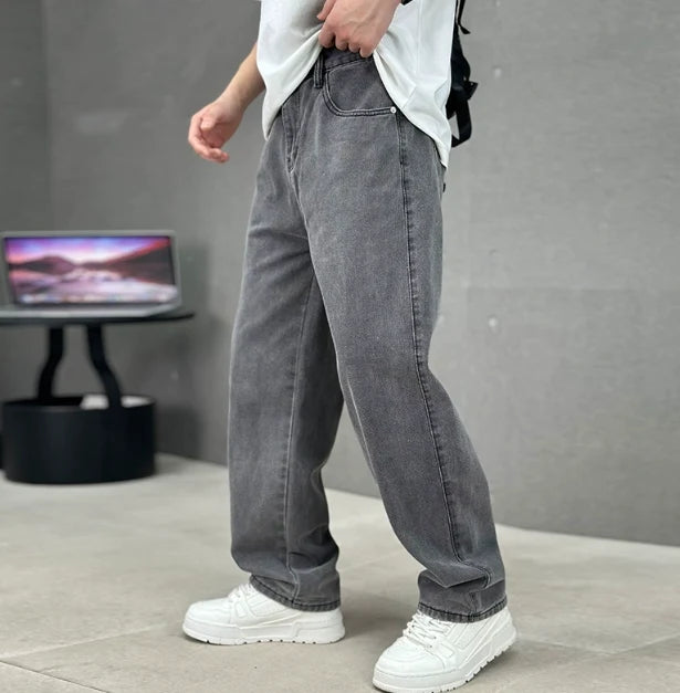 Men's straight leg jeans in washed grey denim with relaxed fit and classic five-pocket styling worn casually