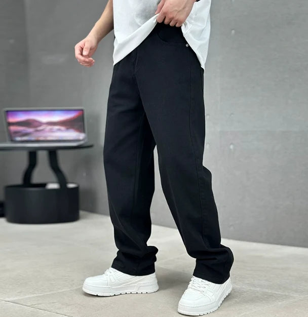 Close-up detail of men's grey jeans featuring button fly closure and slant front pocket construction
