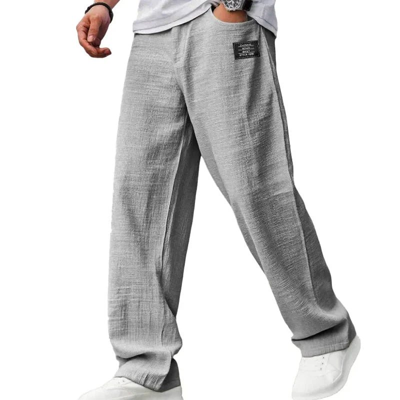 Close-up view of men's grey straight leg trousers showing ribbed fabric texture and hip pocket