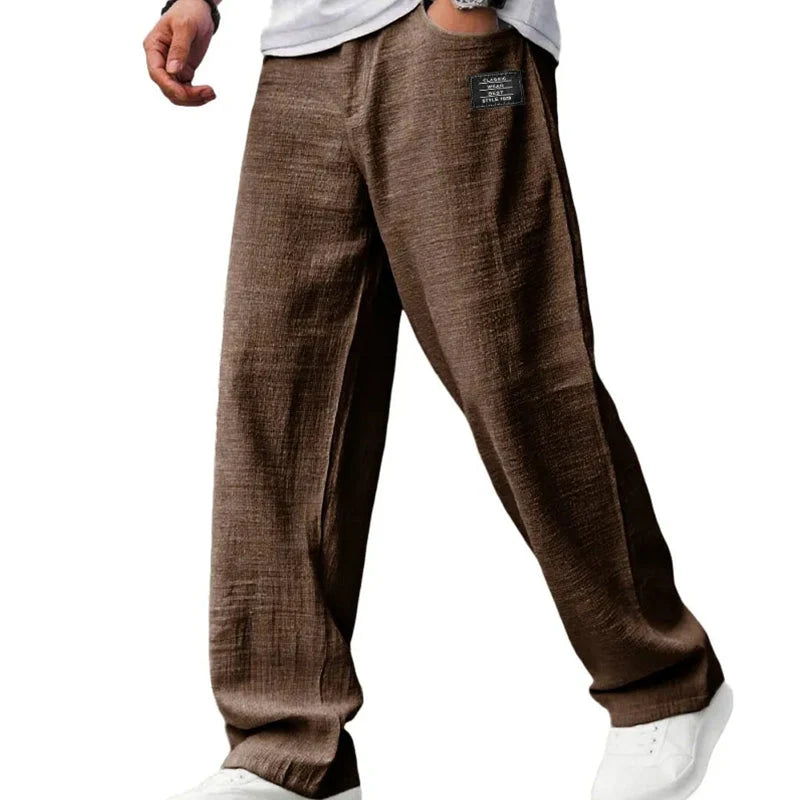 Men's grey straight leg trousers worn with casual footwear demonstrating everyday styling versatility