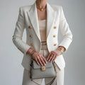 Women's double-breasted blazer in white with gold-tone buttons and notch lapel styled with tailored trousers
