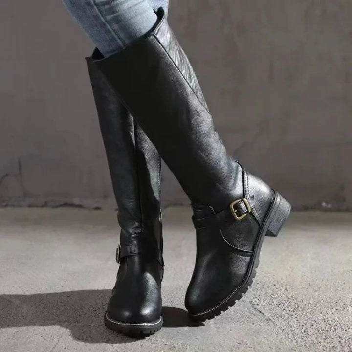 Women's knee-high boots in black featuring structured silhouette and treaded sole