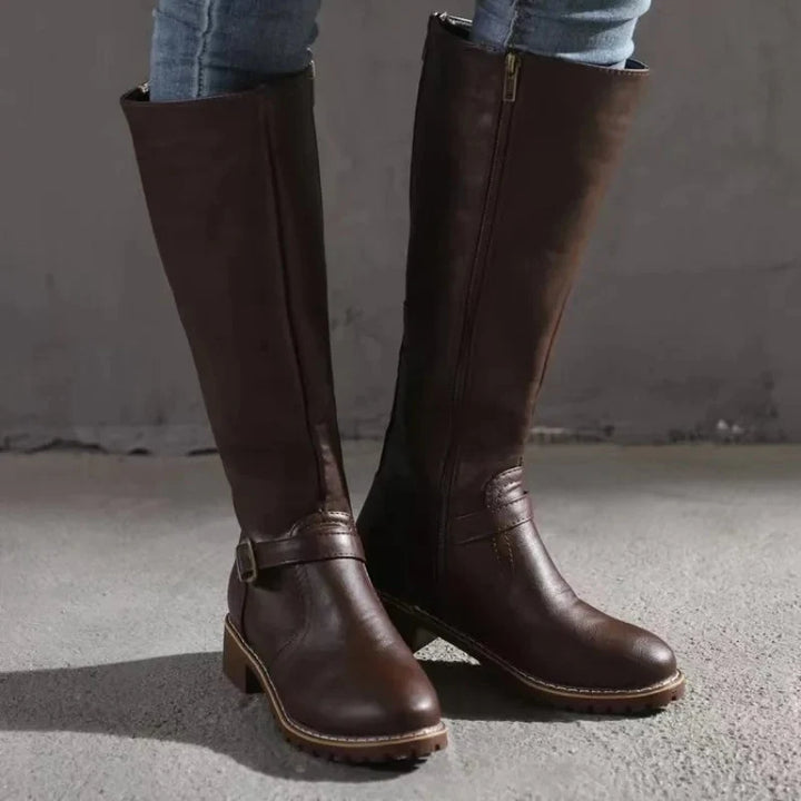 Women's knee-high boots in brown styled with casual trousers for everyday wear