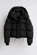 Women's oversized puffer jacket in black with hooded design and cropped quilted silhouette on grey background