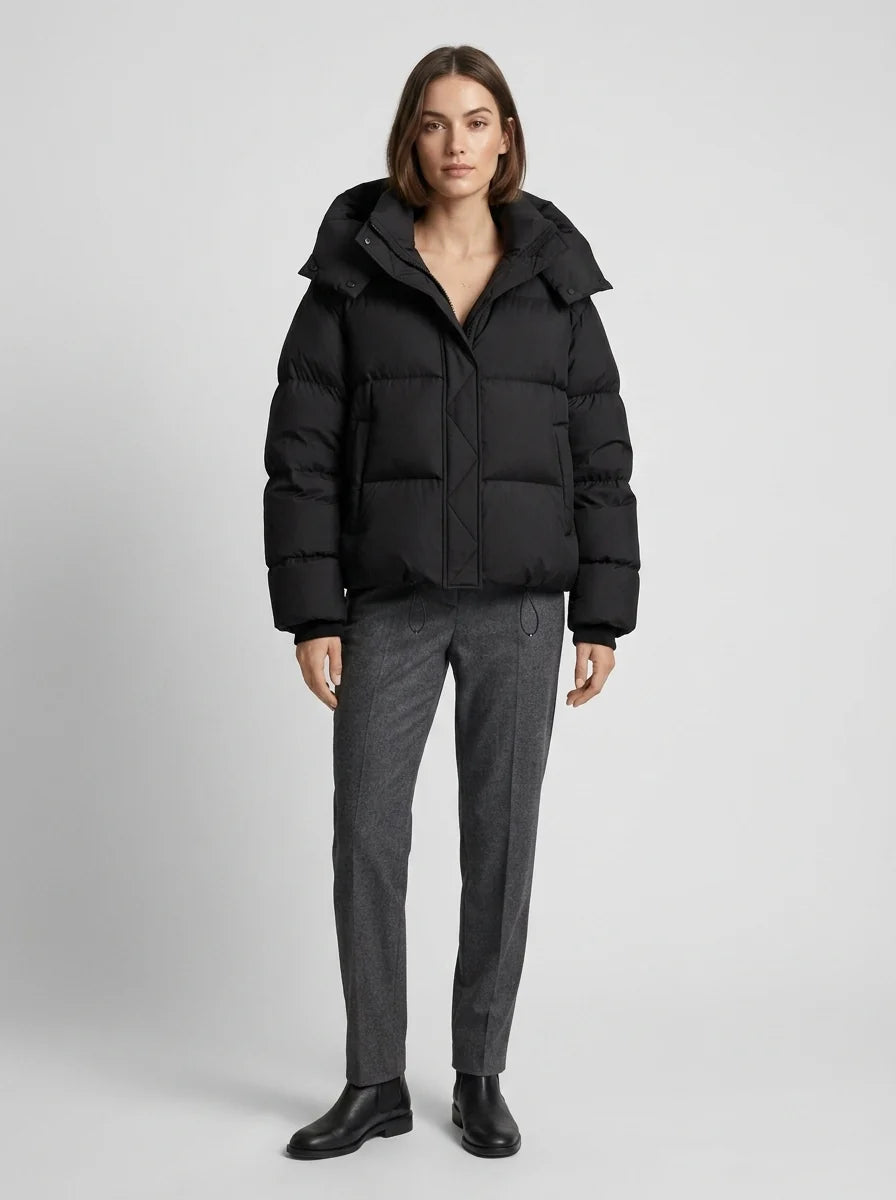 Black oversized puffer jacket front view showing zip closure and voluminous quilted panels with hood