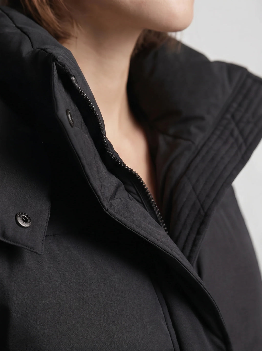 Black puffer jacket back view displaying oversized silhouette and quilted panel detailing