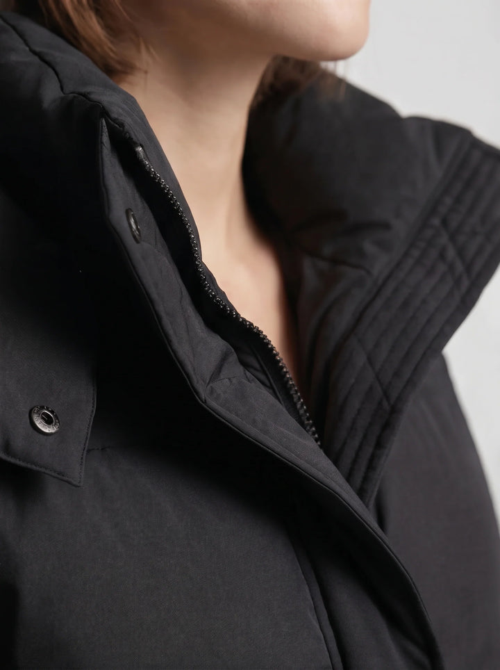Black puffer jacket back view displaying oversized silhouette and quilted panel detailing