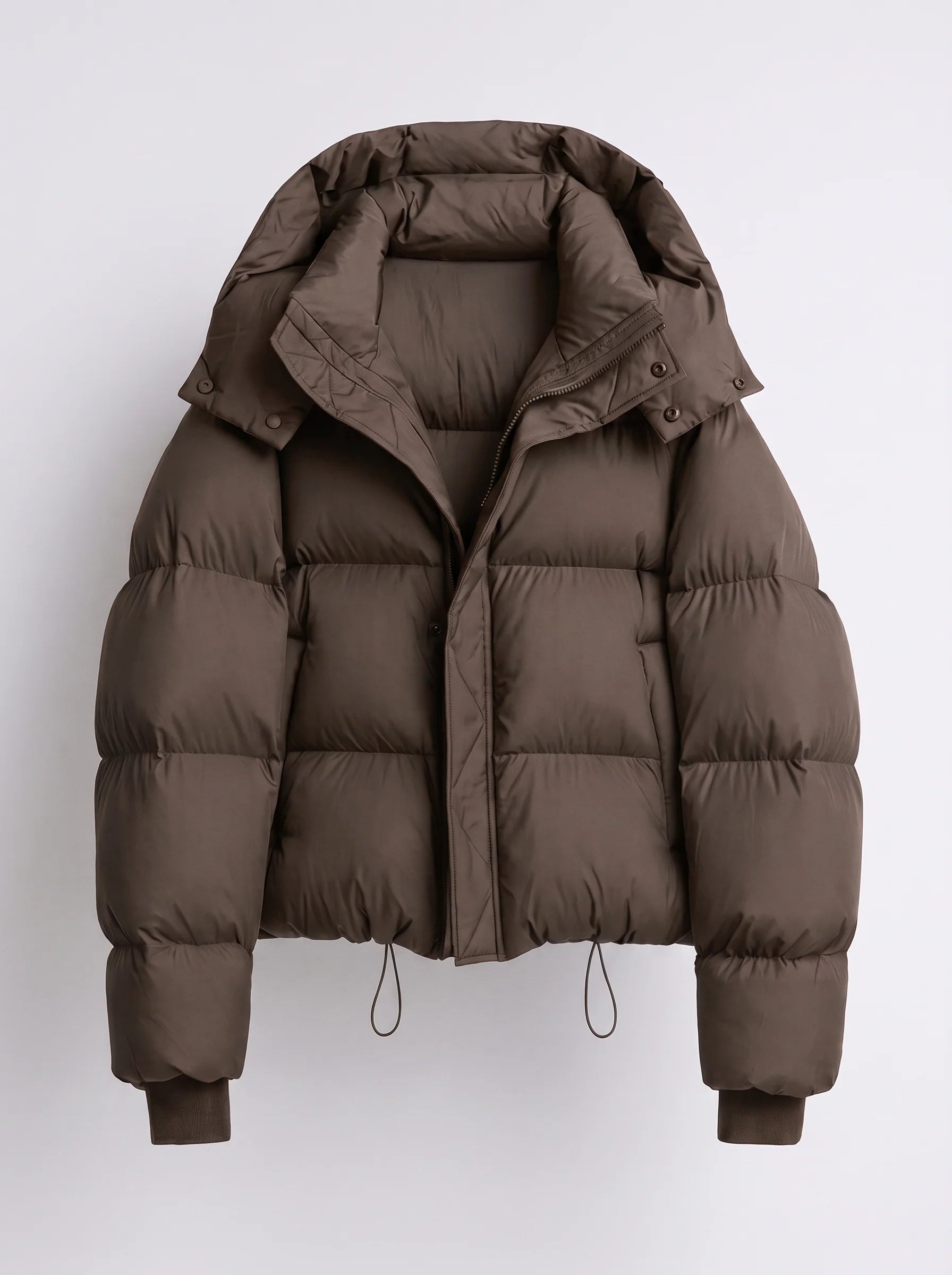 Women's puffer jacket close-up of zip-front closure with snap-button storm flap and hood