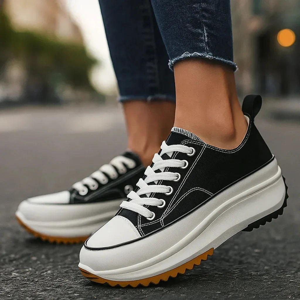 Side view of women's lace-up platform trainers showing elevated chunky sole and animal print canvas upper