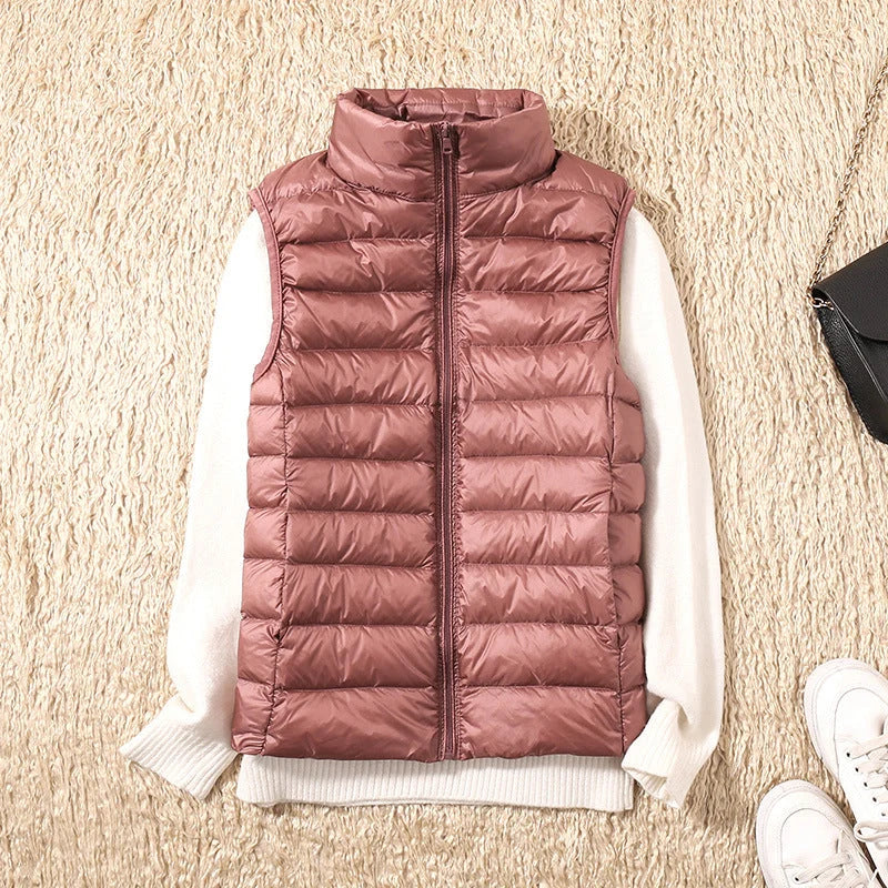 Women's quilted gilet in rose gold with stand collar and full-zip front, styled over a white jumper
