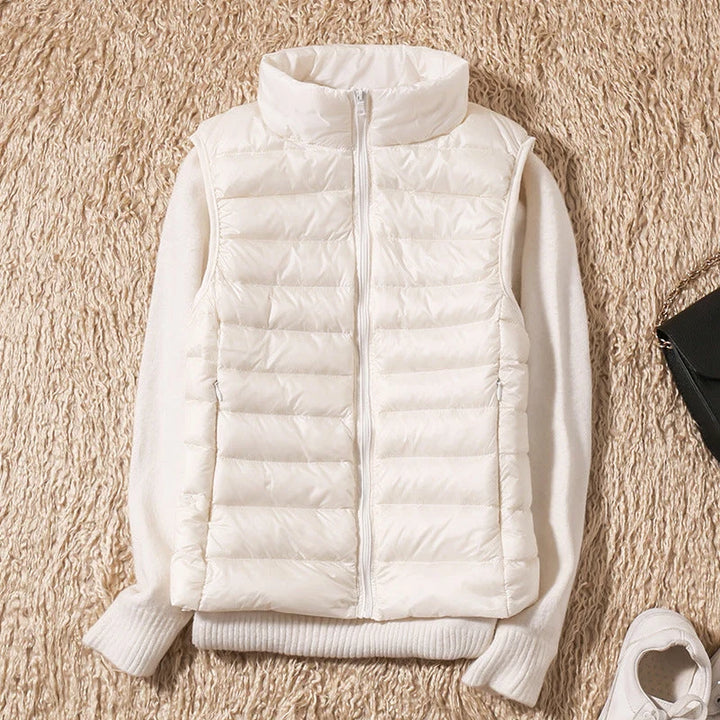 Women's quilted puffer gilet in rose gold displaying layerable fit and hip-length hem