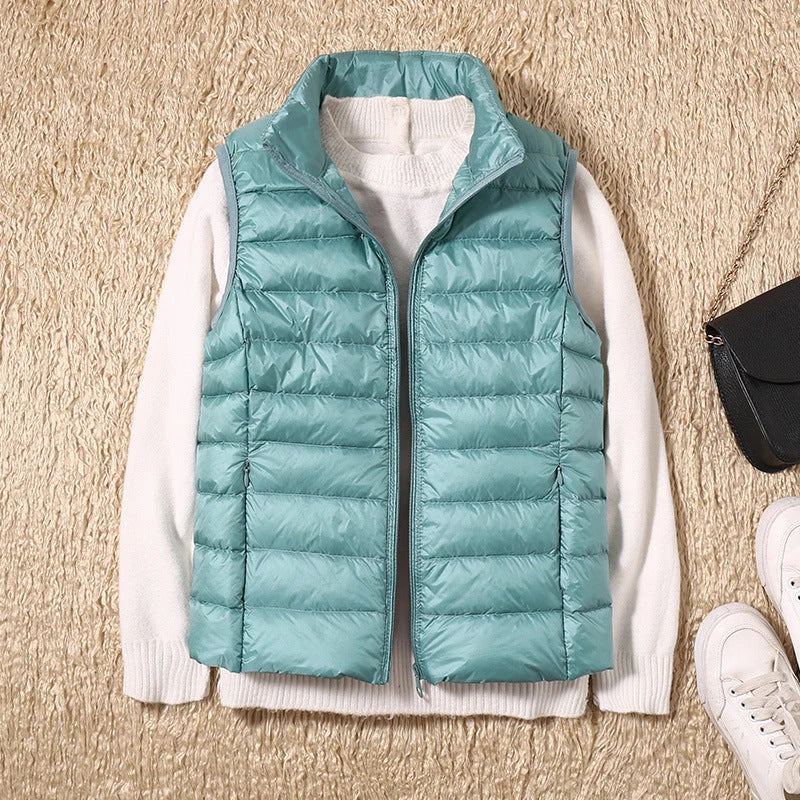 Detail of stand collar and zip front on women's quilted puffer gilet in rose gold