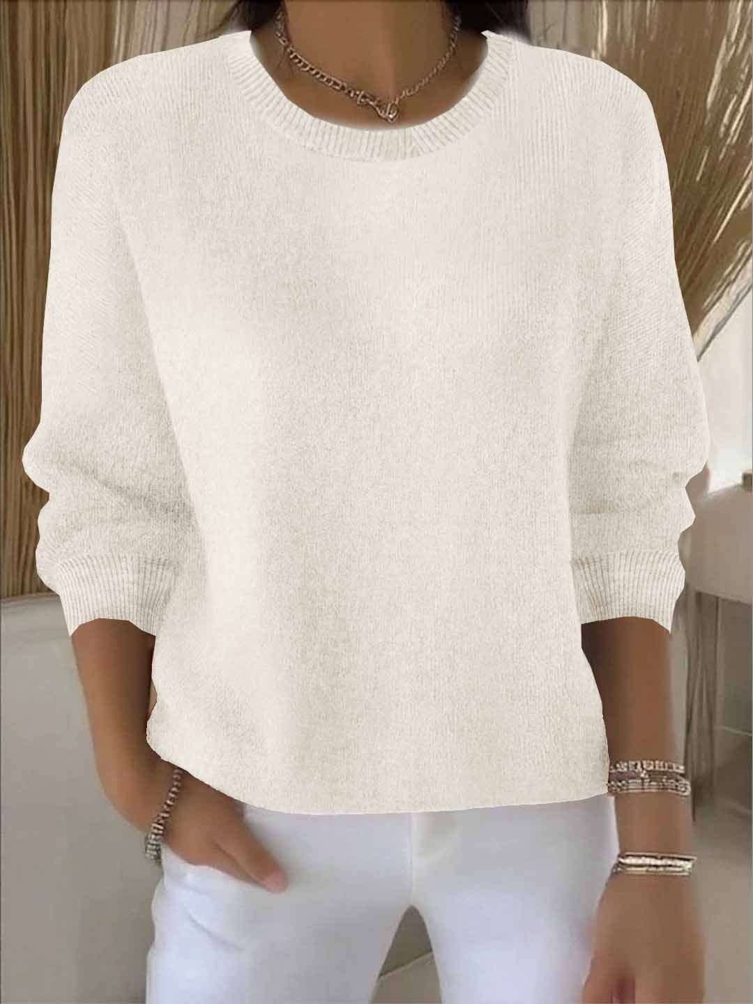 Women's relaxed jumper in blue worn with white trousers showing cropped length and relaxed fit