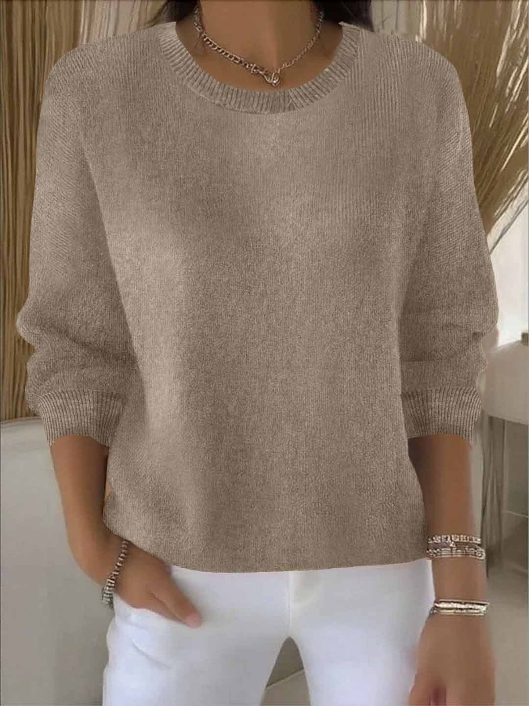Side view of women's knit jumper in pink displaying three-quarter sleeve length and cropped silhouette