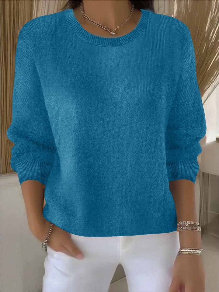 Women's knit jumper in red showing relaxed fit through body and ribbed crew neckline