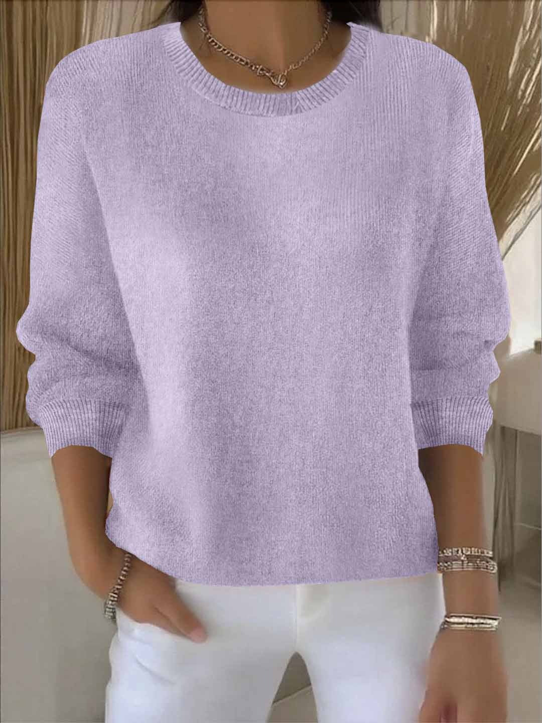 Women's jumper in apricot peach tone displaying fine-gauge knit construction and three-quarter sleeves