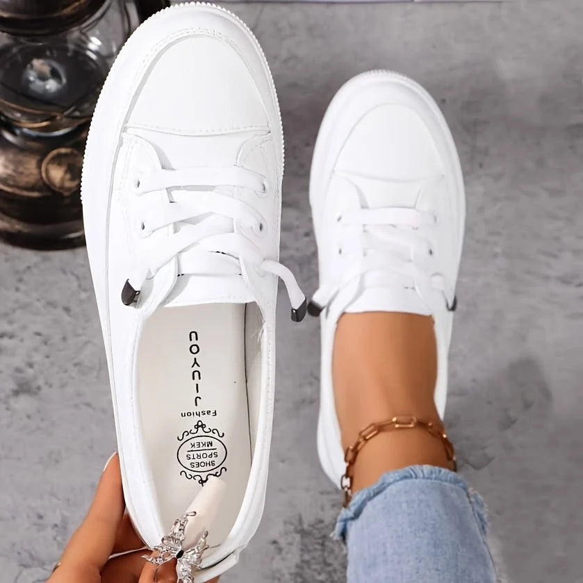 Women's white lace-up trainers with platform sole and cushioned insole, worn with light denim jeans