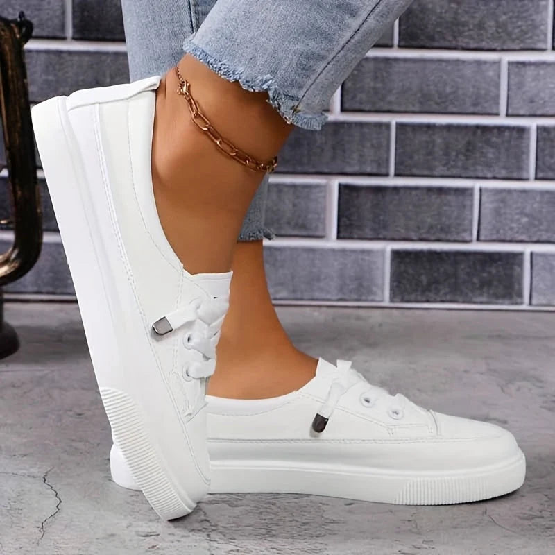 Side view of women's white platform trainers with flat laces and low-top silhouette