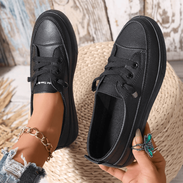 Women's white trainers on foot showing platform sole height and casual styling
