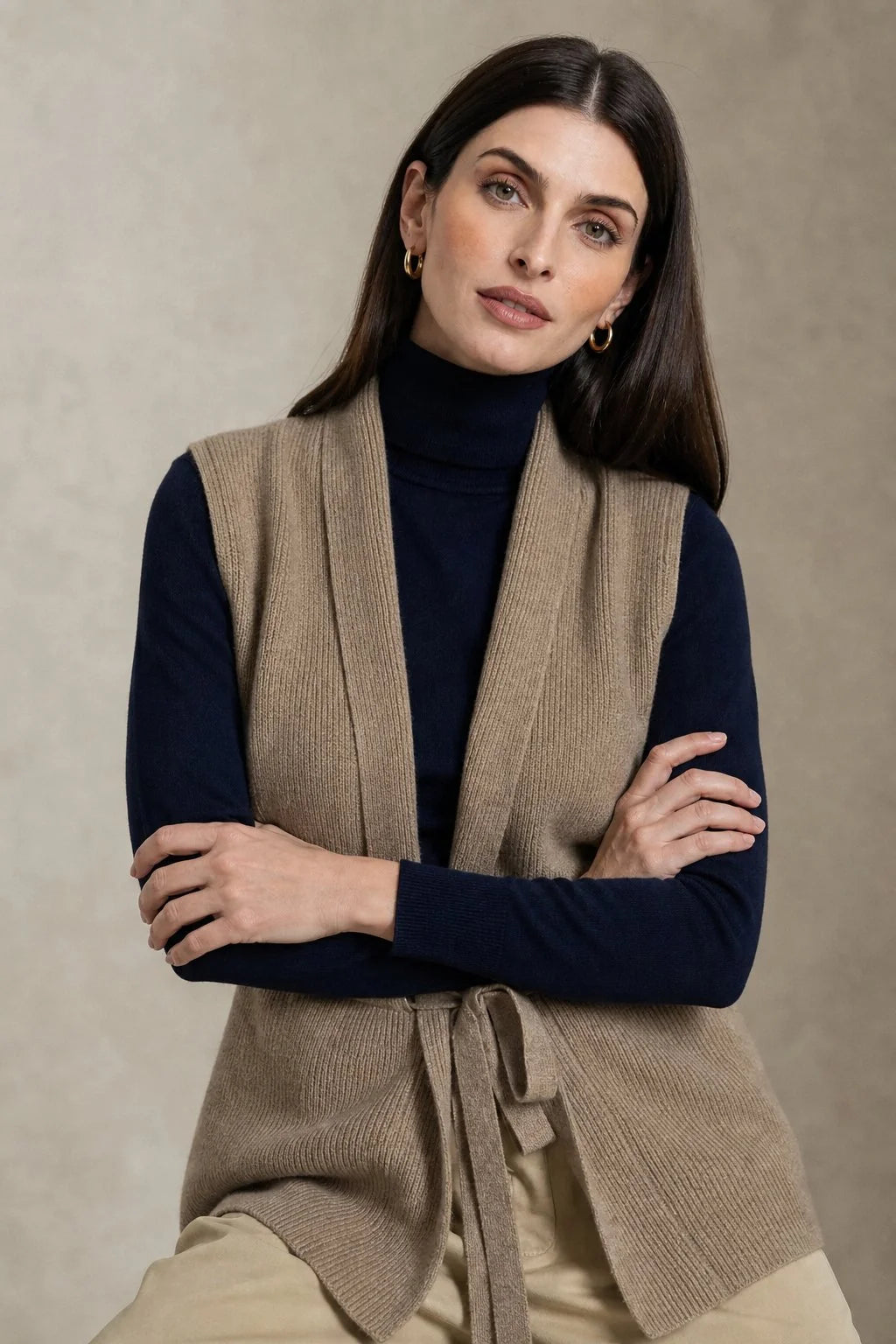 Close-up view of the ribbed knit texture and adjustable waist tie on the cashmere vest